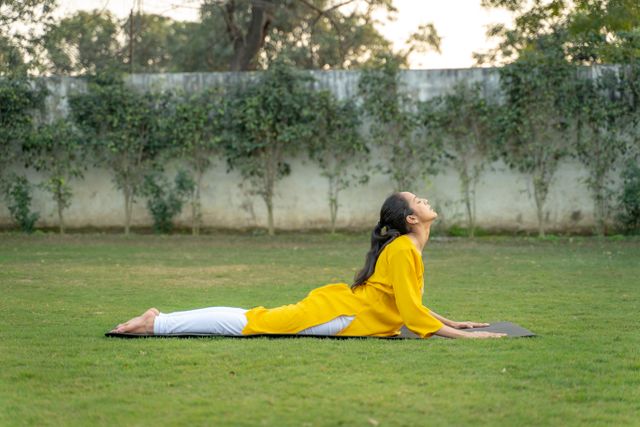 Person performing Bhujangasana cobra pose yoga asana for sciatica and lower back pain relief