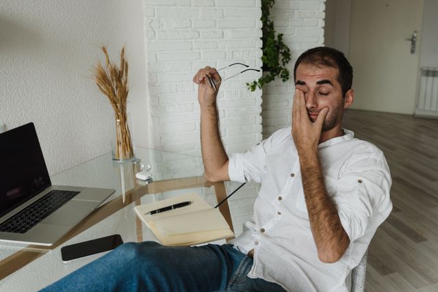 Person experiencing digital eye strain and dry eyes from prolonged mobile and laptop screen use
